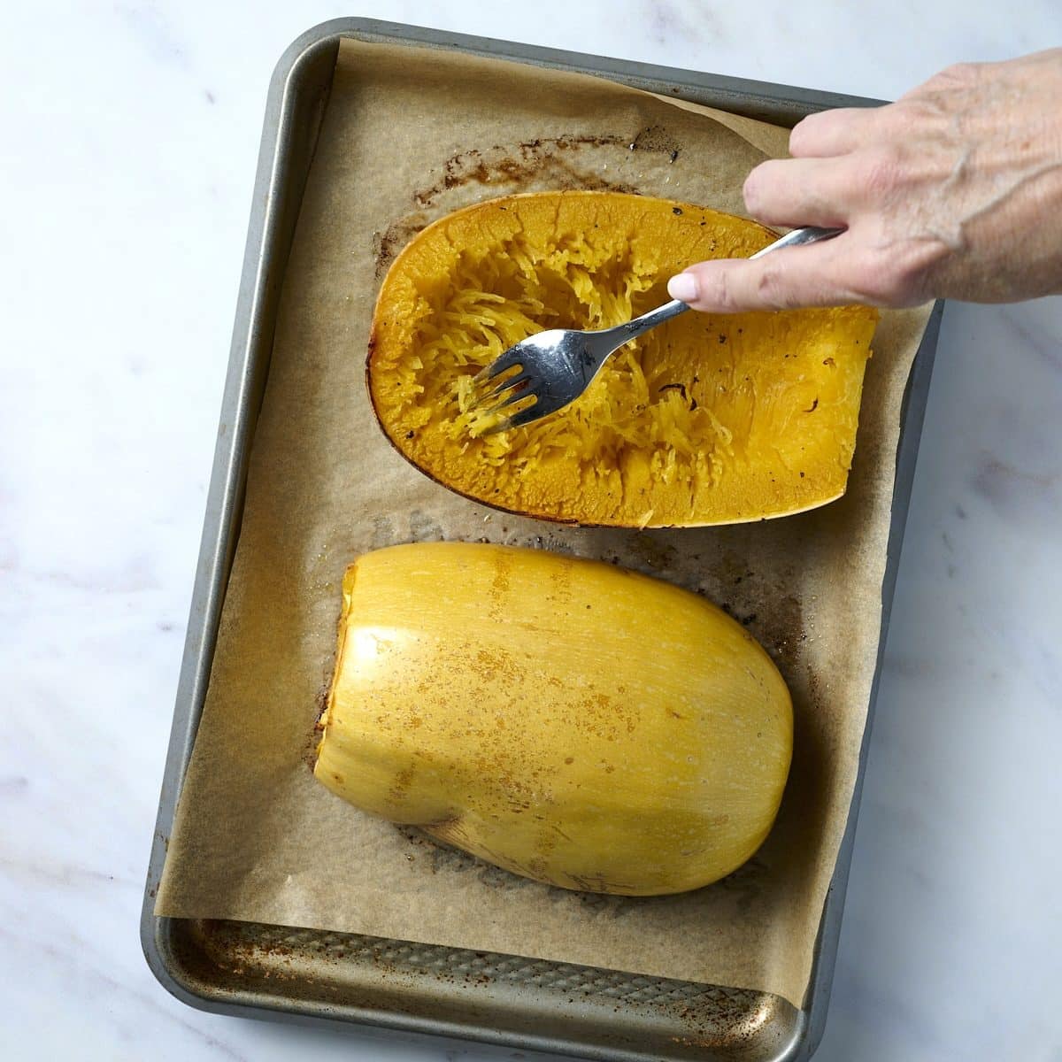 Using a fork to make strands of spaghetti squash 