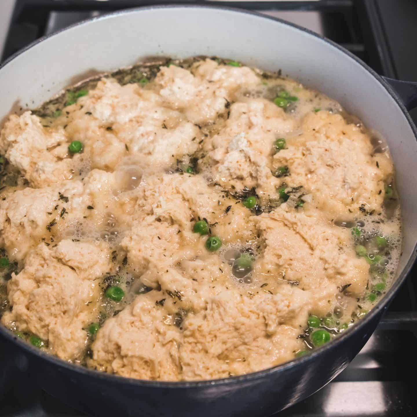 Dumplings bubbling on a pot of chicken soup