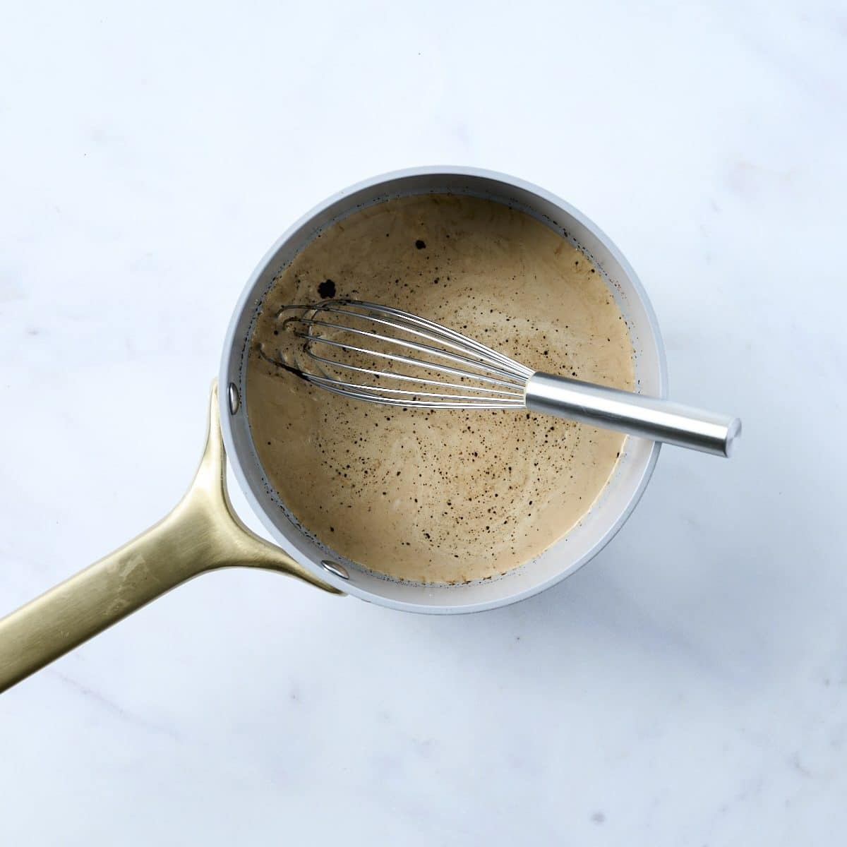 Milk, heavy cream and espresso powder cooking in a small saucepan