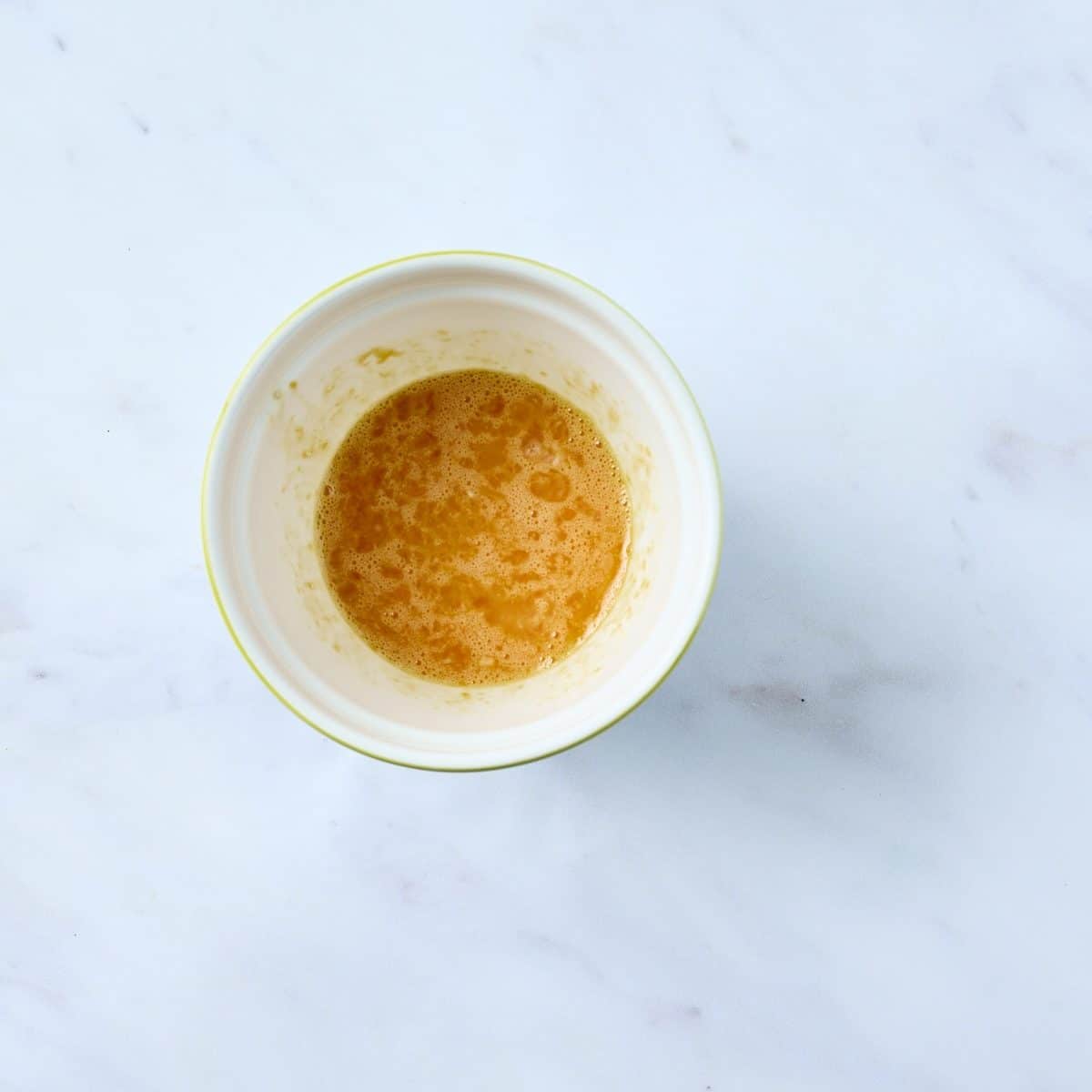 Eggs and sugar mixed in a small bowl