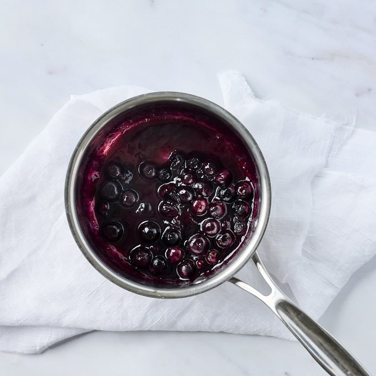 Cooked blueberry compote in a small saucepan