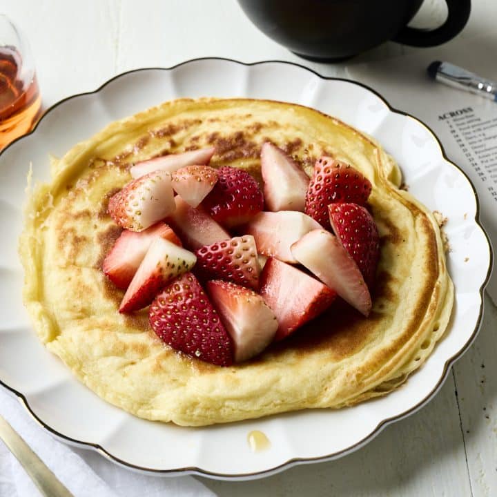 Cottage cheese pancake on a plate with a cup of coffee