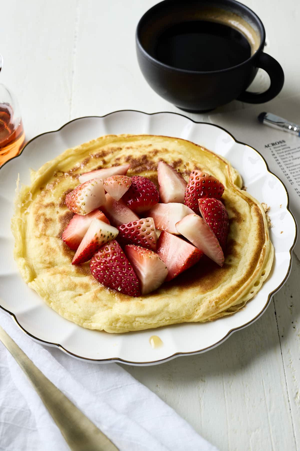 Cottage cheese pancake on a plate with a cup of coffee