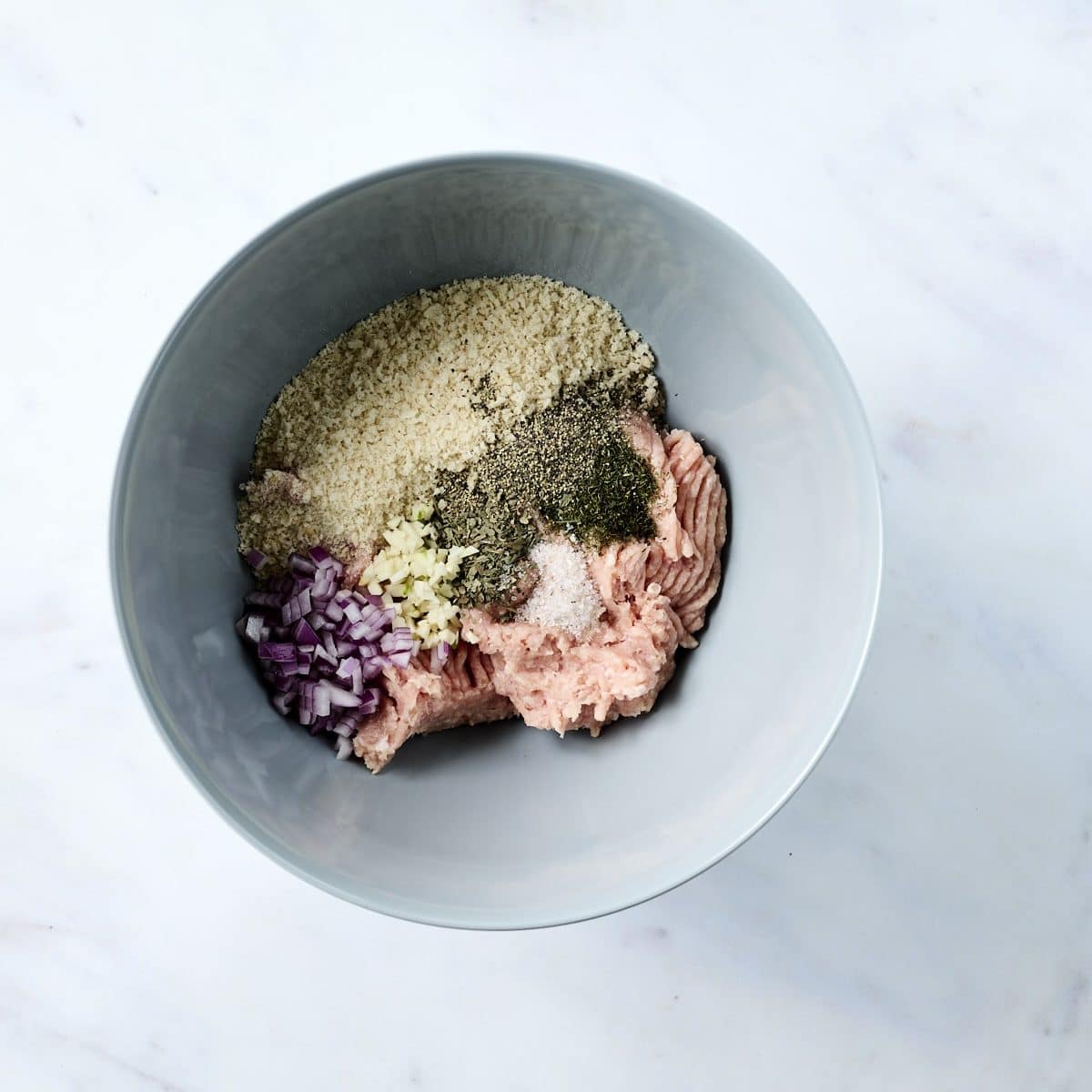 Ground chicken, panko bread crumbs, dill and oregano in a mixing bowl