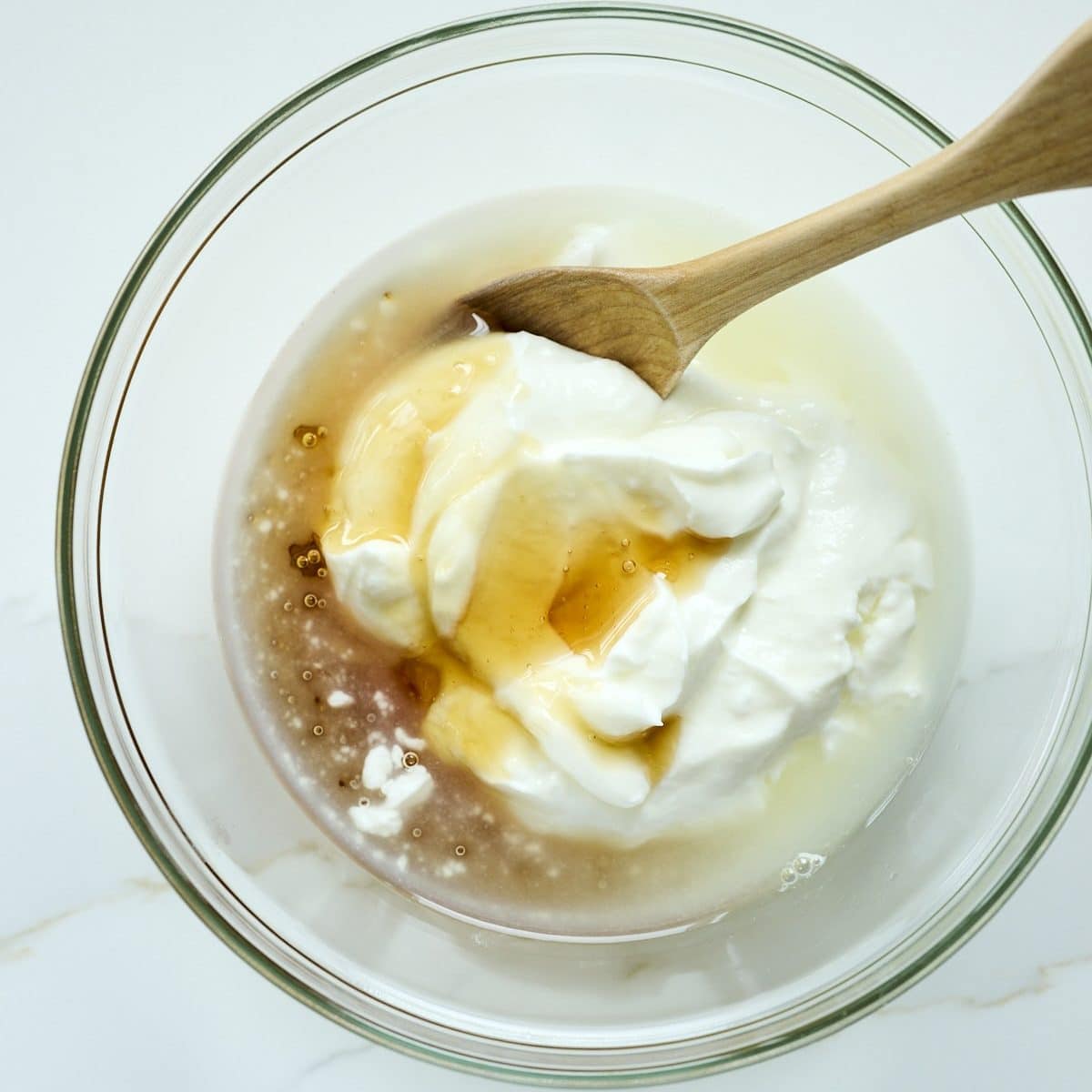Greek yogurt, honey and lemon juice in a glass bowl
