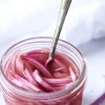Pickled red onions in a low glass jar
