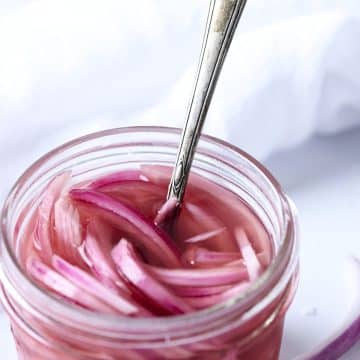 Pickled red onions in a low glass jar