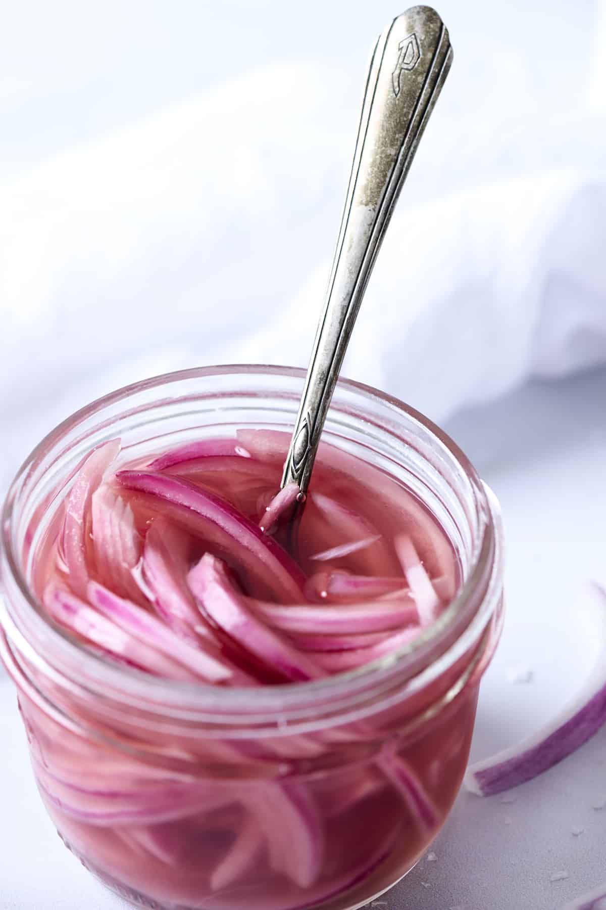Pickled red onions in a low glass jar