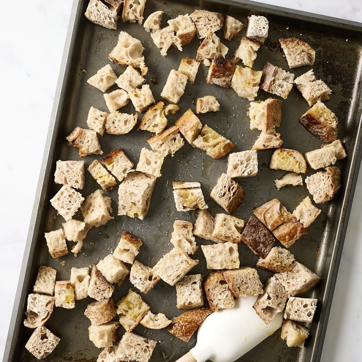 Sourdough bread cubes on a large baking sheet