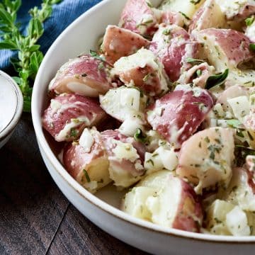 Red skinned potato salad in a low cream bowl