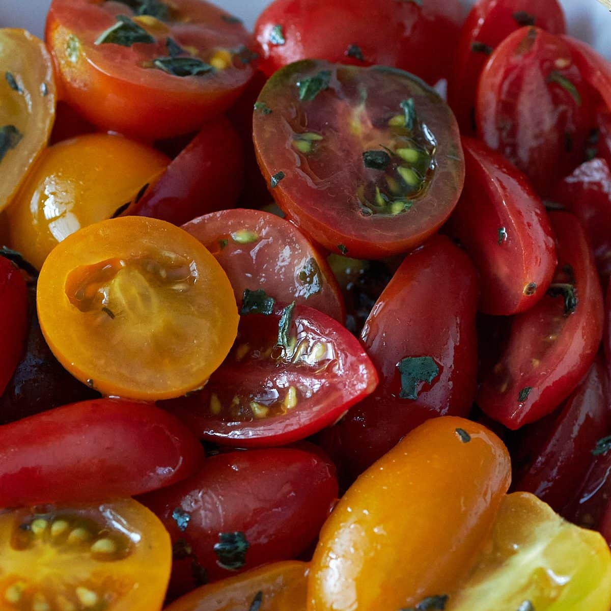 Close up shot of sliced red, orange and yellow grape tomatoes